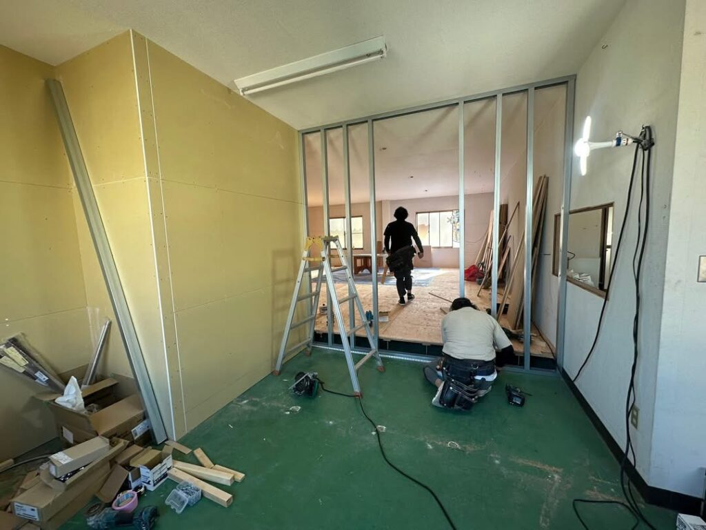 倉庫内の床座上げ作業を行う職人の様子