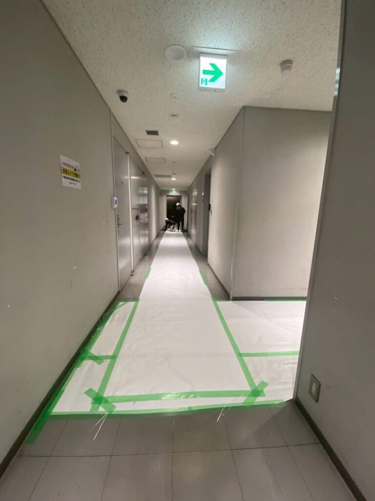 ホワイトカーペット(養生材)を敷いたオフィスの廊下